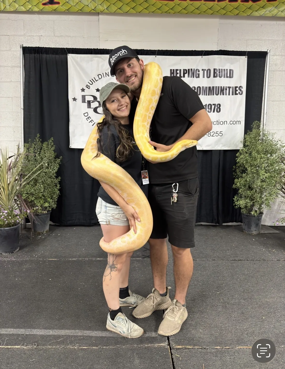 Tyler and Jasmyn at their expo booth wrapped in a python