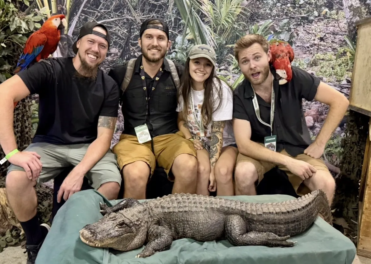 The crew with an alligator and two macaws