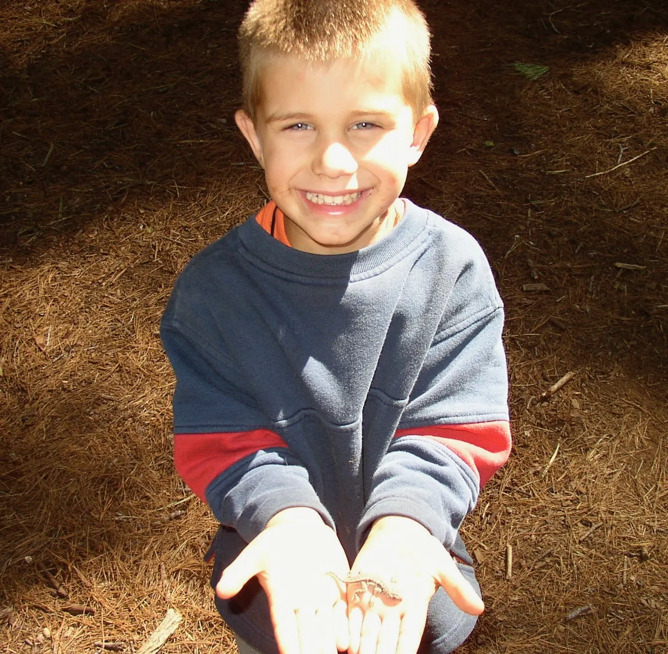 Tyler as a kid, holding a lizard
